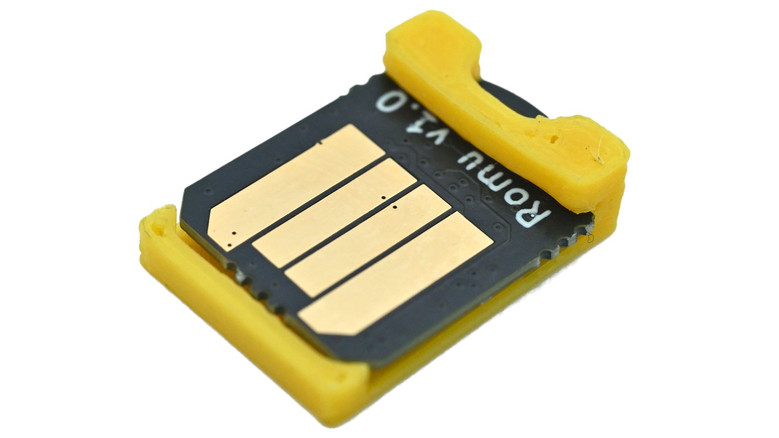 Black Bitmerse Romu board with four gold USB contacts in a yellow protective shim