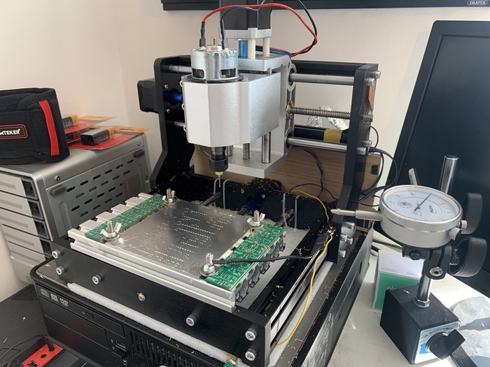 A typical CNC set up with a computer, runout tool, and sacrificial backplate
