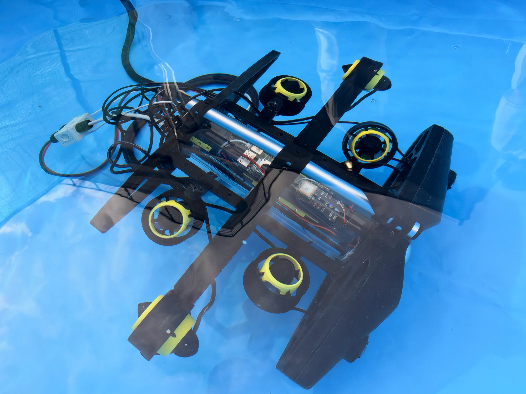 Roma Tre ROV in a tank with visible thrusters, tether and electronics housing