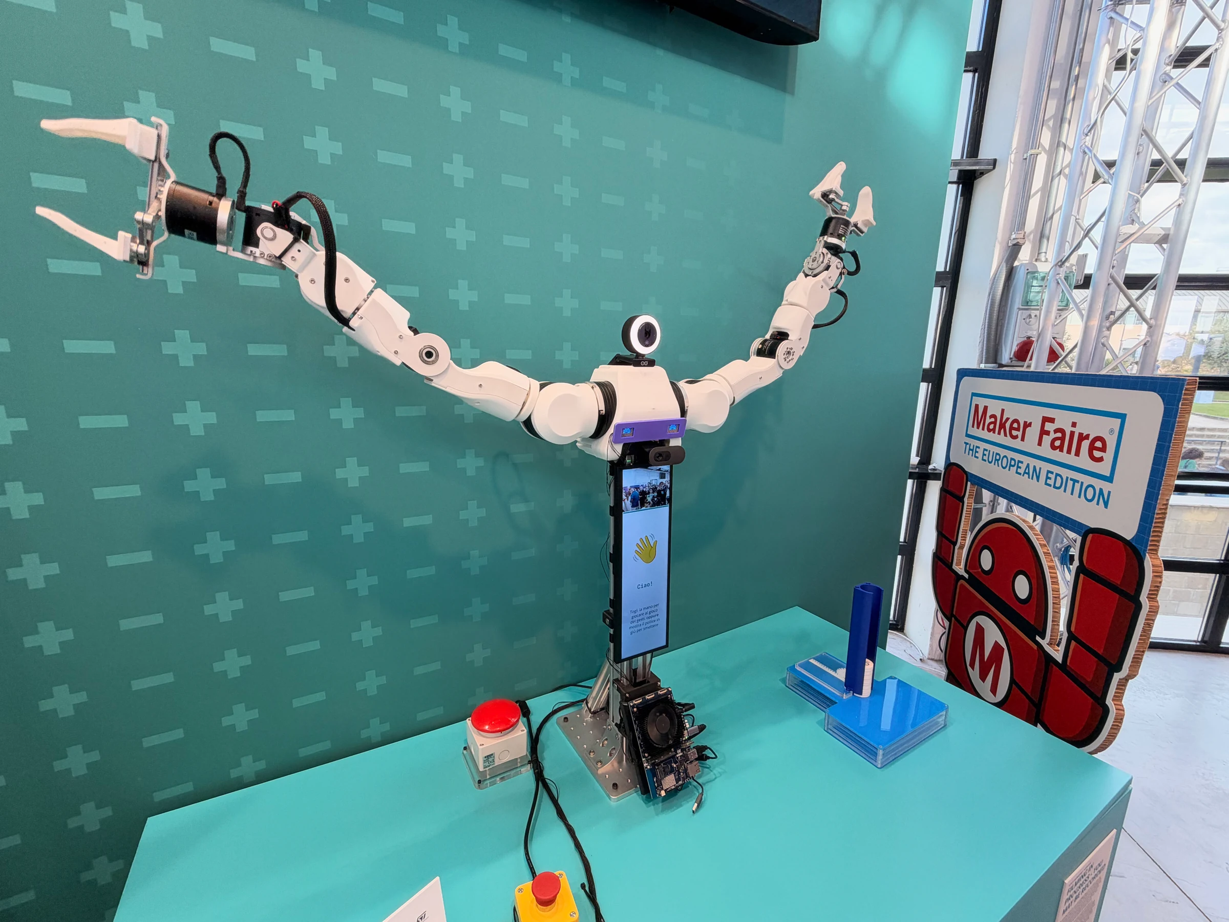 Arduino Agility A2 dual-arm robot with white articulated arms raised beside a vertical screen and cameras.
