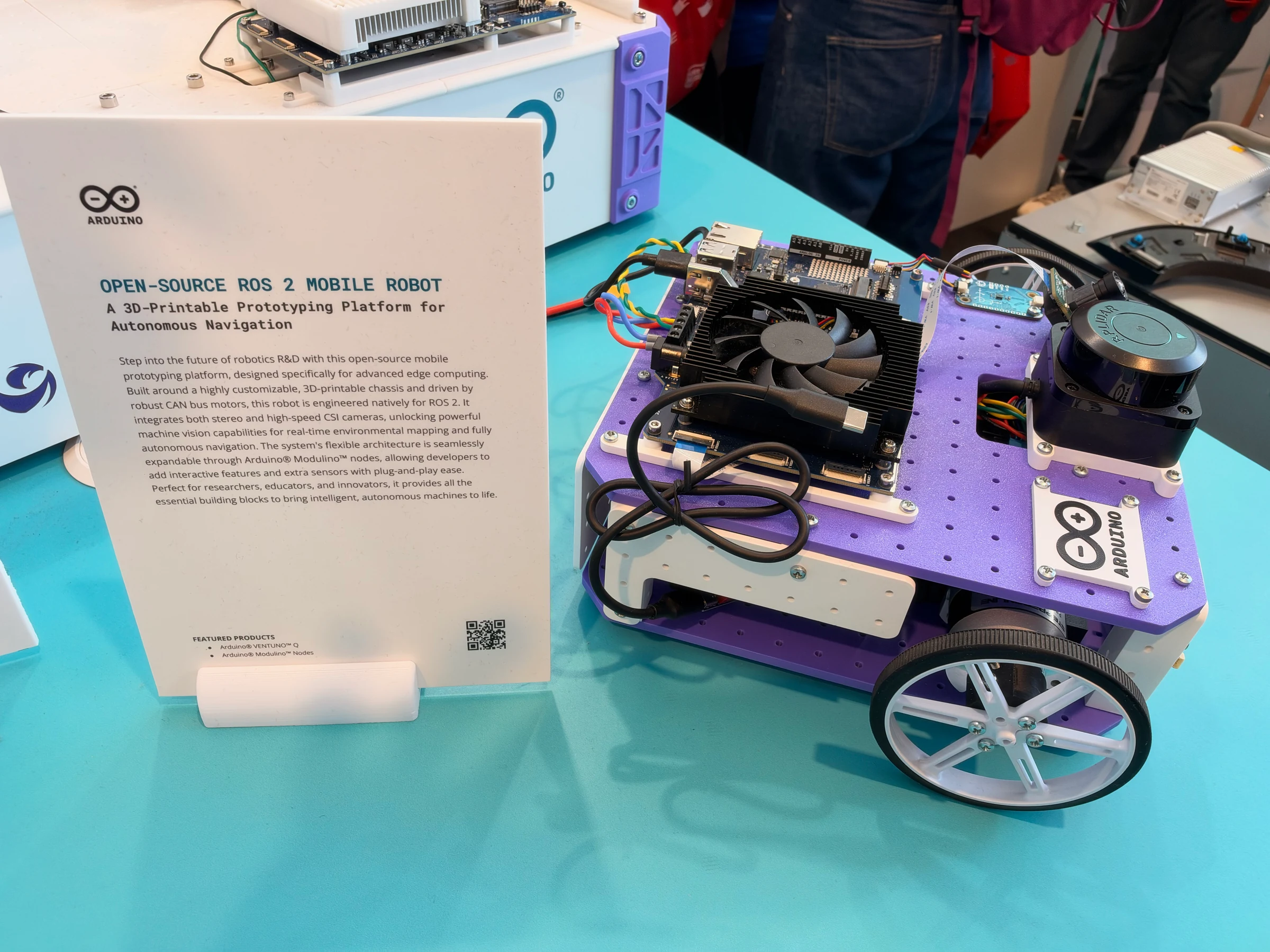 Purple-and-white Arduino mobile robot prototype with a lidar scanner, exposed circuit boards, cooling fan, and large wheels.