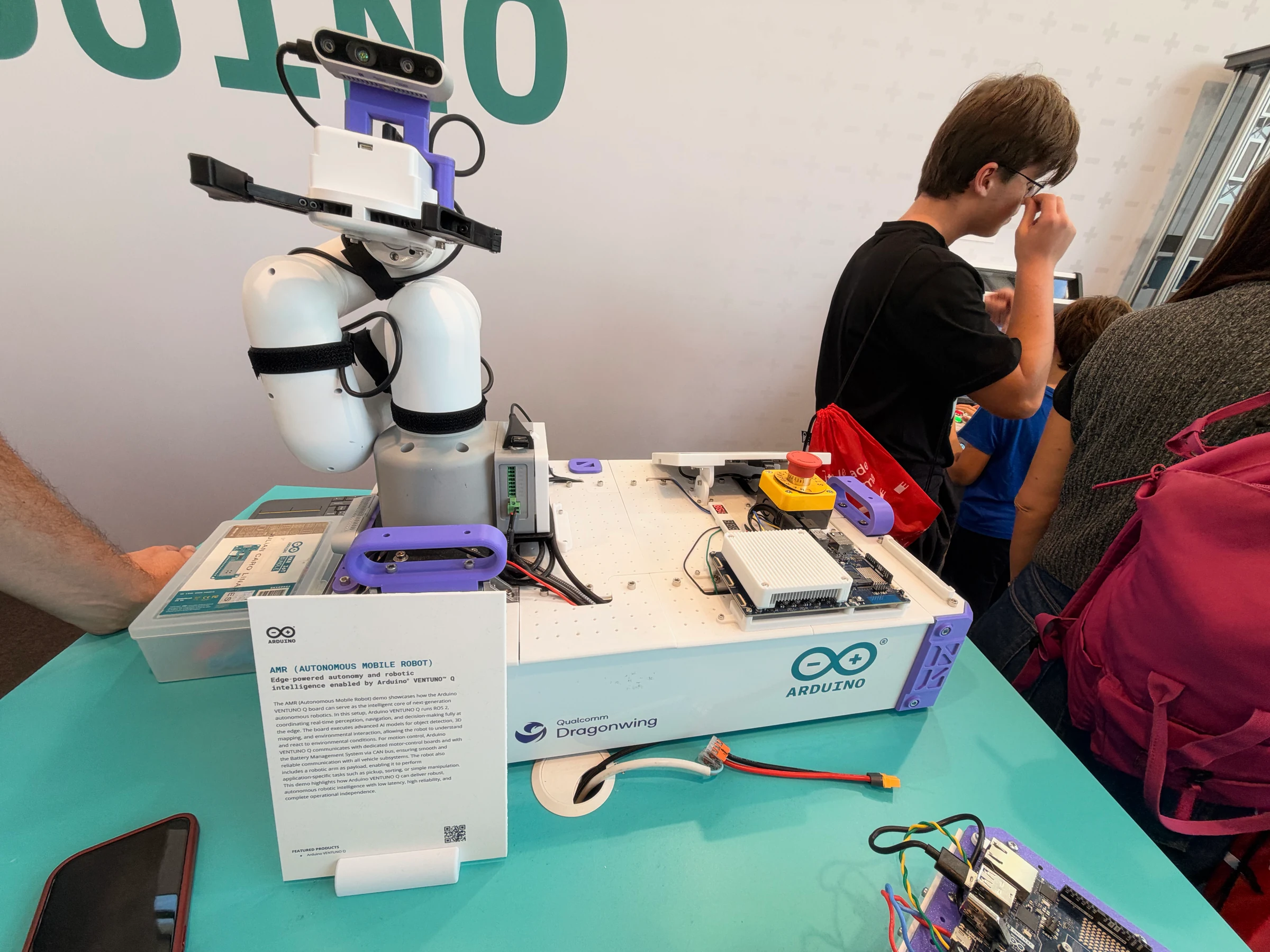 Larger white Arduino autonomous mobile platform carrying a folded robotic arm, vision sensor, and exposed computing hardware.