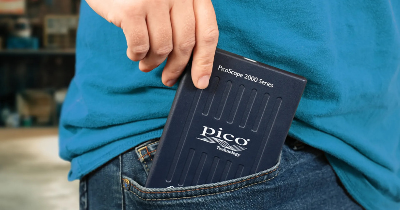 A compact PicoScope 2000 Series USB oscilloscope being slipped into a jeans pocket.